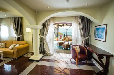 a living room with a couch and a chair at Helena VIP Villas and Suites - Half Board in Sunny Beach