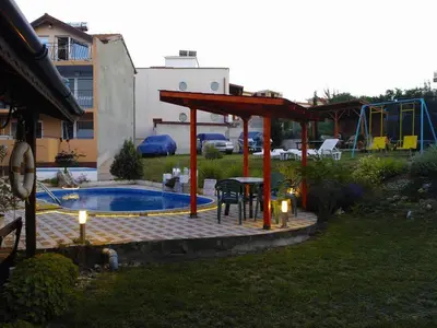 a patio with a table and a pavilion next to a pool at Guest House Evin Rai in Byala