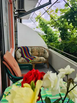 a balcony with a couch and a table with flowers at Guest House Evin Rai in Byala