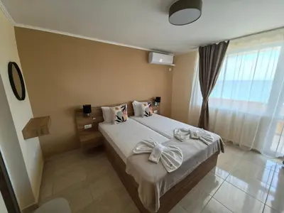 a bedroom with a bed with a bow on it at Family Hotel Alfa Vita in Sozopol