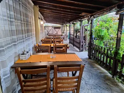 a row of tables and chairs on a patio at Guest House Starata Kushta in Lozenets