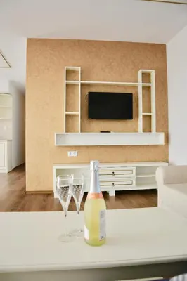 a living room with a bottle of wine and wine glasses at Golden Rainbow Beach Hotel in Sunny Beach