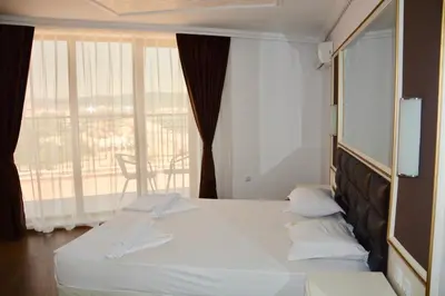 a hotel room with a bed and a large window at Golden Rainbow Beach Hotel in Sunny Beach