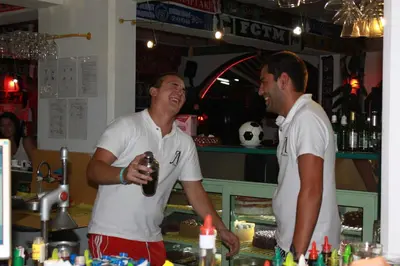 two men are standing in a bar with a drink at Hotel Levteri in Primorsko