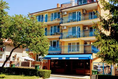 a tall yellow building with blue balconies on it at R&G Hotel in Nesebar