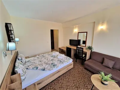 a bedroom with a bed and a couch and a desk at Family Hotel Diana in Tsarevo