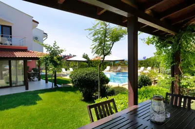 an outdoor table with a view of a yard at Saint Stefan Villas in Sozopol