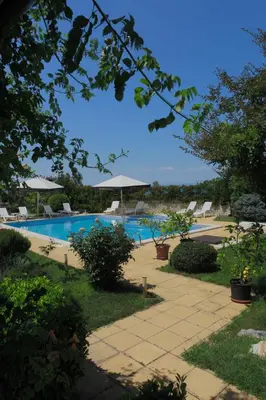 a swimming pool with chairs and umbrellas in a yard at Saint Stefan Villas in Sozopol