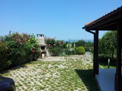 a backyard with a yard with a chair and flowers at Saint Stefan Villas in Sozopol