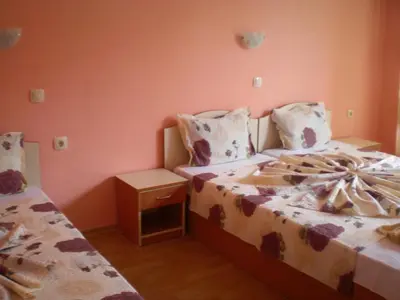 a bedroom with two beds and a night stand at Hotel Sirena in Primorsko