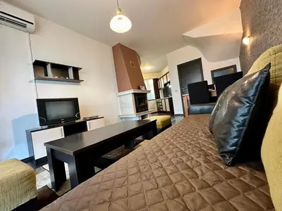 a living room with a bed and a couch and a television at Menada Imperial Heights Villas in Sunny Beach
