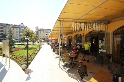 a restaurant with tables and chairs and people sitting at tables at Menada Royal Sun Apartments in Sunny Beach