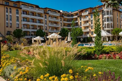 a hotel with a garden in front of a building at Menada Royal Sun Apartments in Sunny Beach