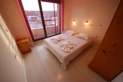 a bedroom with a large bed with towels on it at Menada Horyzont Apartments in Sozopol