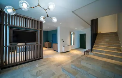a living room with stairs and a flat screen tv at HVD Reina del Mar - Premium Spa Service & Free Parking in Obzor