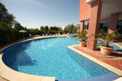 a large blue swimming pool in a building at Menada Apartments in Sunny Beach in Sunny Beach