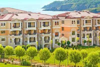 an image of a large building with trees at Menada Kavaci Sozopol Apartments in Sozopol
