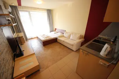 a small living room with a couch and a window at Menada Kavaci Sozopol Apartments in Sozopol