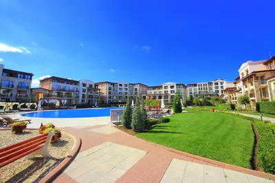 a park with a bench and some apartment buildings at Menada Kavaci Sozopol Apartments in Sozopol