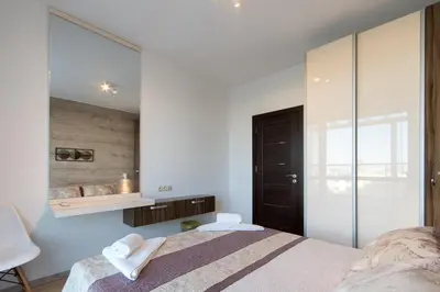 a bedroom with a bed and a mirror at City Apartments Triumph in Varna City