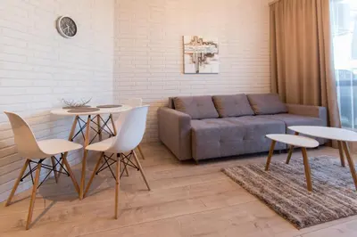 a living room with a couch and a table and chairs at City Apartments Triumph in Varna City