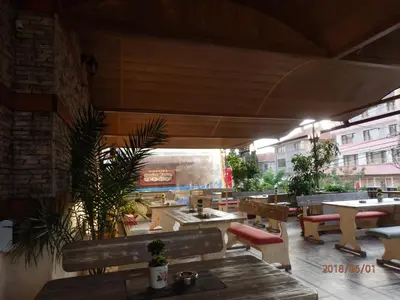 a restaurant with wooden tables and benches and tables at Guest house Napoli in Ravda