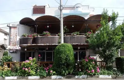 a building with flowers and plants in front of it at Guest house Napoli in Ravda
