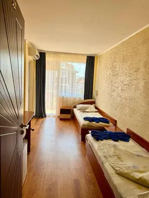 a hotel room with two beds and a window at Guest house Napoli in Ravda
