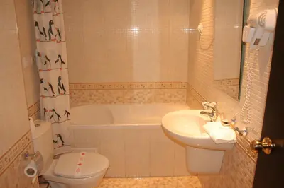 a bathroom with a sink and a toilet and a tub at Aparthotel VRIS in Tsarevo