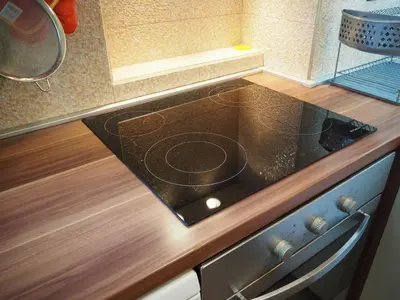a stove top in a kitchen with a wooden counter top at Yoana Apartment in Varna City