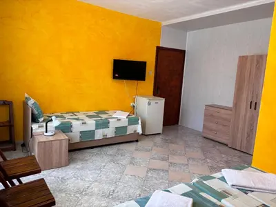 a room with two beds and a television in it at Guest House Nikolovi in Lozenets