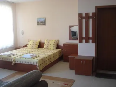 a bedroom with a bed and a dresser at Villa Rouge in Sozopol