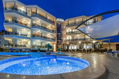 a hotel with a swimming pool in front of a building at Семеен хотел Адена in Chernomorets