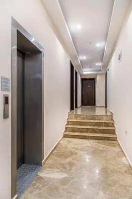 a hallway with stairs leading to a door at Семеен хотел Адена in Chernomorets