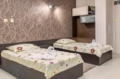 two beds with towels on them in a bedroom at Семеен хотел Адена in Chernomorets