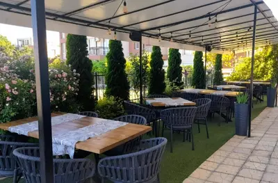 a patio with tables and chairs under a canopy at Family Hotel Saga in Ravda
