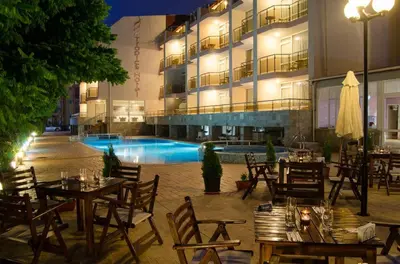 an outdoor restaurant with tables and a pool in front of a building at Hotel Tropics & Venera - Ultra All Inclusive in Sveti Vlas