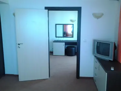 a room with a tv and a bathroom with a mirror at Hotel Bellisimo in Lozenets