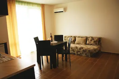 a living room with a table and chairs and a couch at Guest House ASK in Primorsko