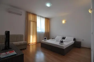 a living room with a bed and a couch at Guest House ASK in Primorsko