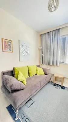a living room with a couch with yellow pillows at Venum in Varna City