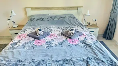 a bed with a blue and white comforter and pillows at Venum in Varna City