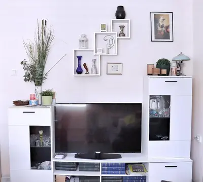 a white entertainment center with a large television in a living room at Venum in Varna City