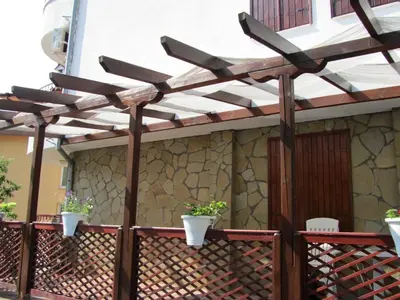 a pergola on a fence with two potted plants at House Sofia in Sveti Vlas