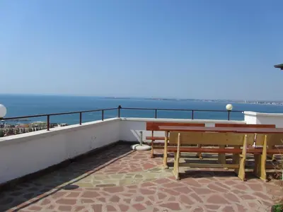 a balcony with tables and a view of the ocean at House Sofia in Sveti Vlas