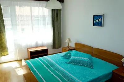 a bedroom with a bed with blue sheets and a window at House Prodanovi in Sozopol