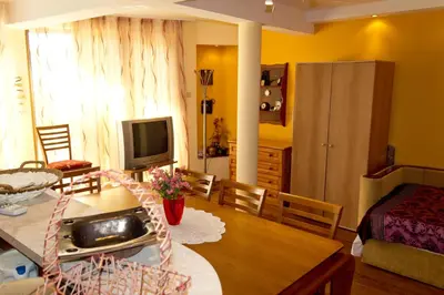 a kitchen and living room with a table and a television at House Prodanovi in Sozopol