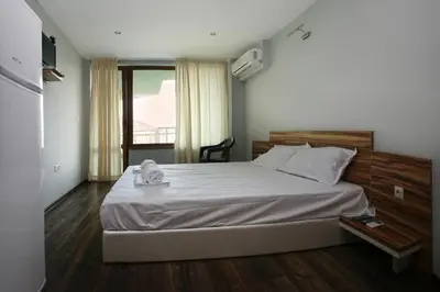 a bedroom with a large bed with a wooden headboard at JBH Hotel in Sveti Vlas