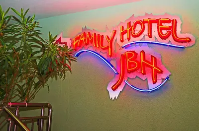 a neon sign that says any hotter bits on a wall at JBH Hotel in Sveti Vlas