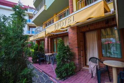 a restaurant with tables and chairs outside of a building at JBH Hotel in Sveti Vlas